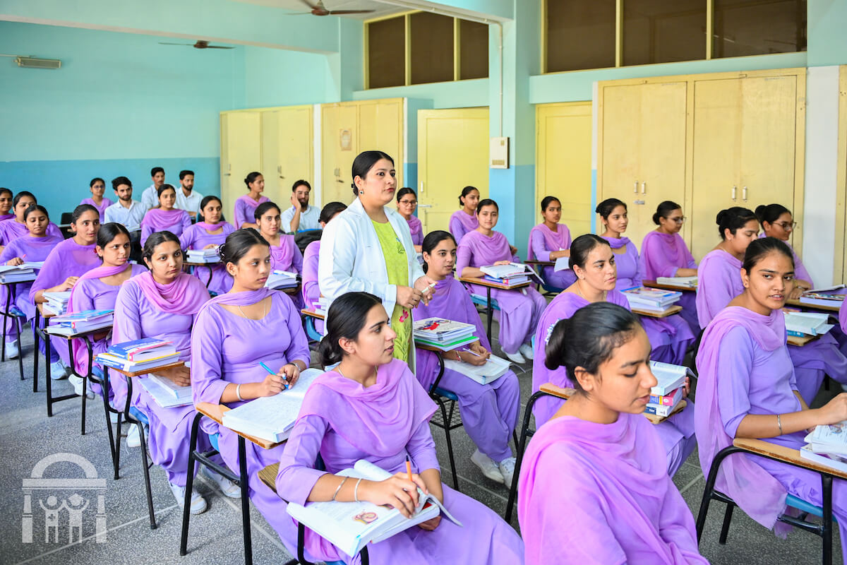 Guru Nanak College of Nursing Classroom from left front angle with teacher walking along student desk rows - Nursing college in Dhahan Kaleran near Banga