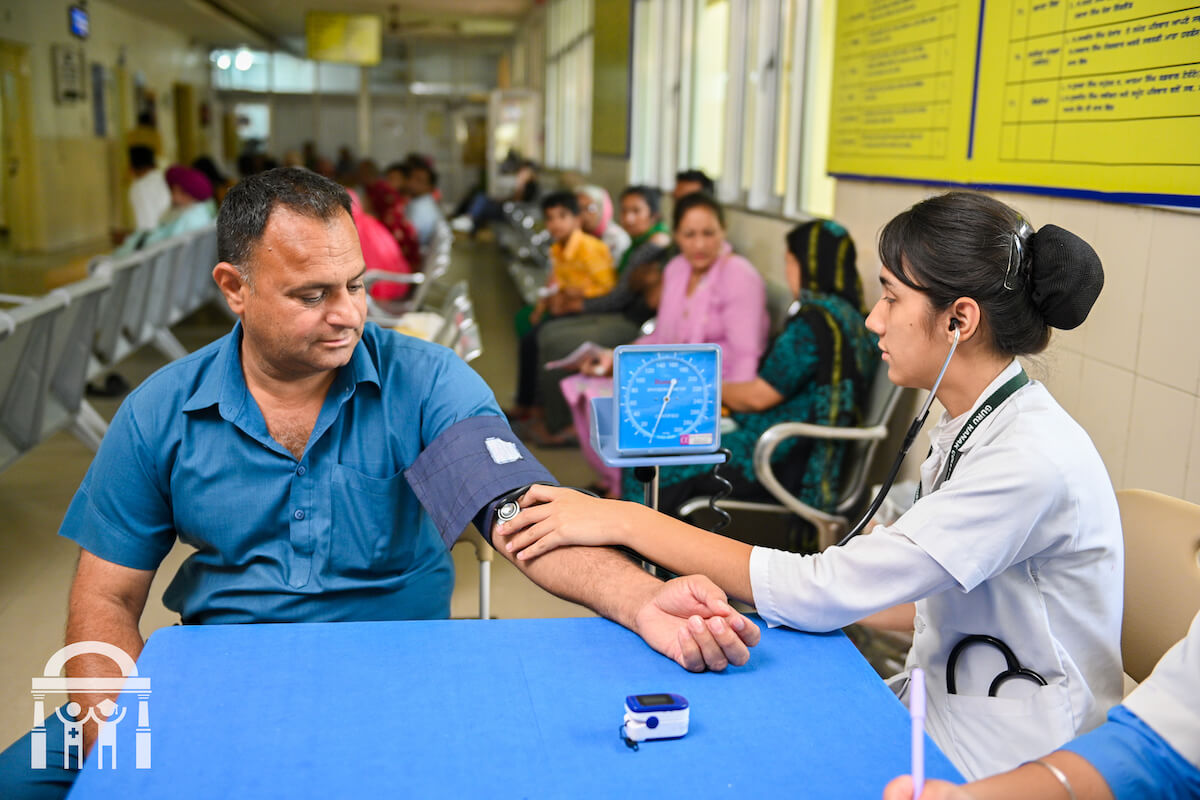 Guru Nanak College of Nursing student in clinical practice taking blood pressure reading